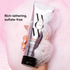 Shampoo bottle with lather on a pink background, labeled 'Rich-lathering, sulfate-free'.