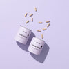 Two containers labeled 'Hair Food' with scattered capsules on a light purple background